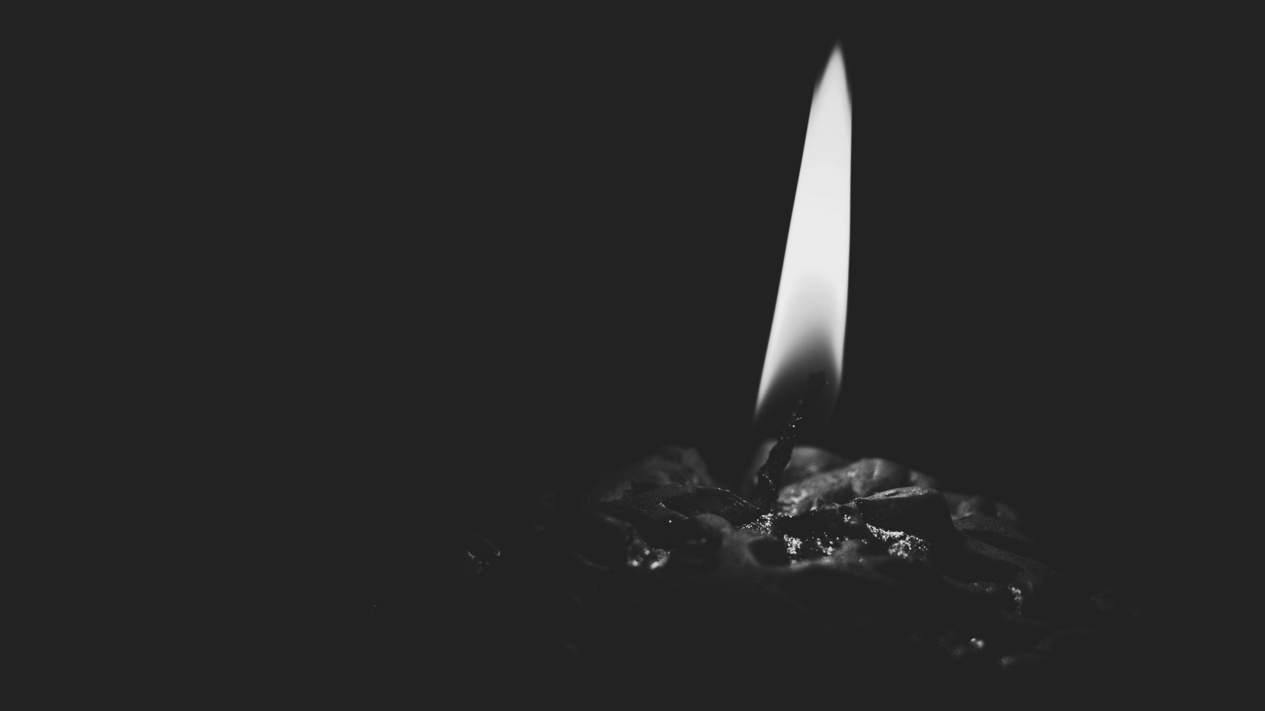 A captivating black and white close-up of a candle's burning flame casting shadows.